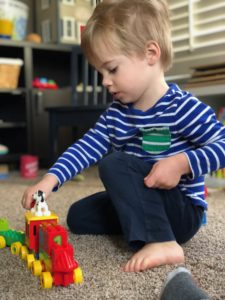 toddler playing with toy train
